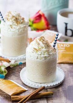 two desserts with whipped cream and cinnamon sticks on a table next to each other