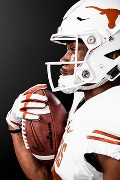 a man holding a football in his right hand and wearing a white uniform with an orange design on it