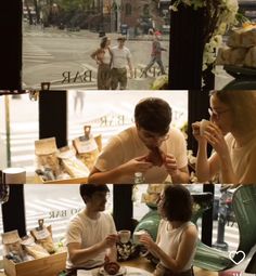 two people sitting at a table in front of a window eating food and talking to each other