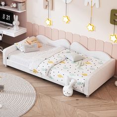 a white bed sitting on top of a hard wood floor next to a wall mounted clock