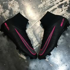 black and pink nike soccer cleats on the ground