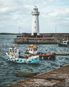 two boats in the water near a light house