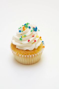 a cupcake with white frosting and sprinkles on it's top