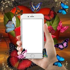 a person holding up a smart phone with butterflies surrounding it