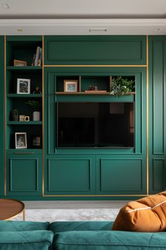 a living room filled with furniture and a flat screen tv mounted on a wall next to a green couch