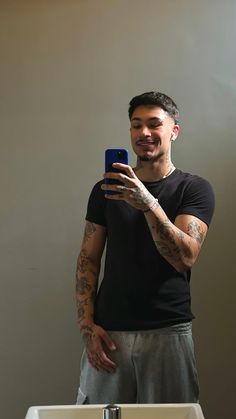 a man taking a selfie in front of a bathroom mirror with his cell phone