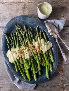 asparagus on a blue plate with dressing