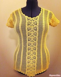 a crocheted yellow top on a mannequin headdress is shown