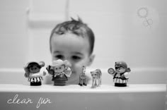 a baby in the bathtub looking at toy figurines