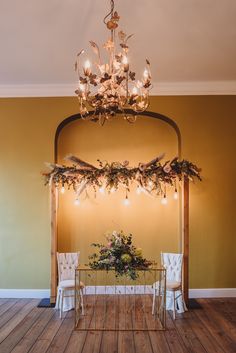 a dining room table with chairs and a chandelier hanging from it's ceiling