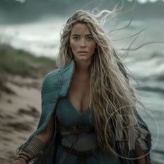 a woman with long hair standing on the beach