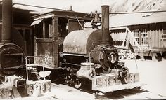 an old steam engine sitting in front of a building