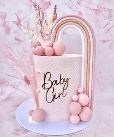 a baby girl cake with pink and gold decorations