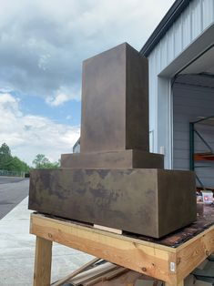 a large metal block sitting on top of a wooden table next to a garage door