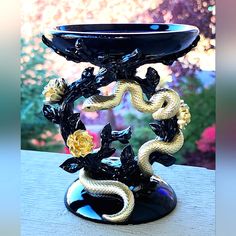 a black and gold vase sitting on top of a table