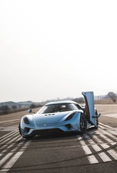 a blue sports car with its door open