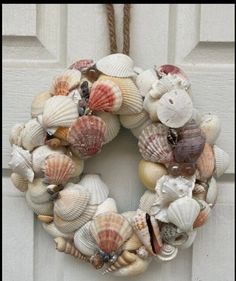 a wreath made out of seashells hanging on a door