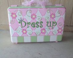 a pink and green suitcase with the word dress up on it's front side