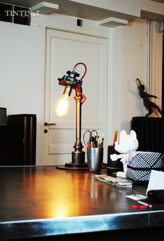 a desk with a lamp on top of it next to a mouse figurine