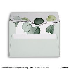 a white envelope with green leaves on it