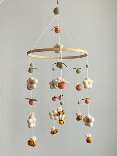 a mobile made out of felt balls hanging from a ceiling fixture in a child's room