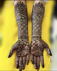 two hands with henna designs on them