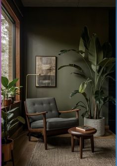 a living room with green walls and plants in the corner, along with a gray chair