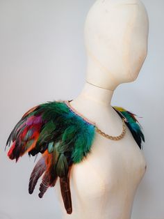 a white mannequin with feathers on it's back and chain around the neck