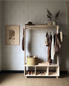 a coat rack with shoes and hats hanging on the wall next to a brick wall