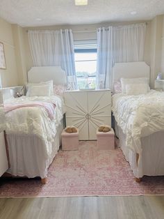 two beds in a bedroom with white linens and pink rug on the floor next to each other