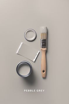 a paintbrush, brush, and some other items on a gray surface with the words pebble grey