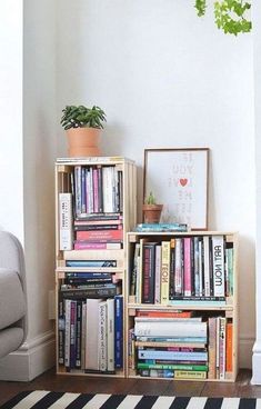 a bookshelf filled with lots of books next to a couch and potted plant