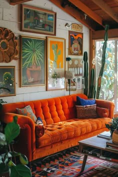 a living room with orange couches and pictures on the wall