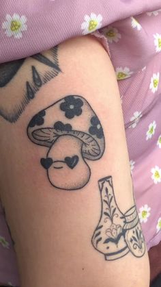 a woman with a tattoo on her arm has a mushroom and boots design on it