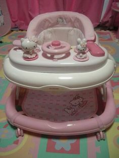 the hello kitty baby walker is pink and has hello kitty decorations on it's side