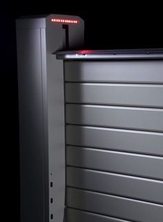 an electronic device is sitting on top of a metal cabinet with red lights in it