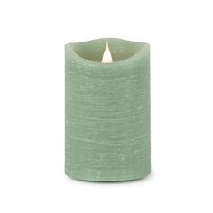 a green candle that is lit on a white background