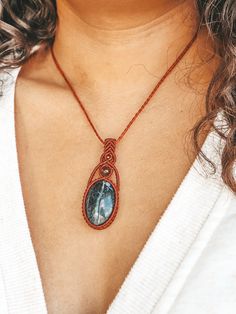 a woman wearing a necklace with a blue stone