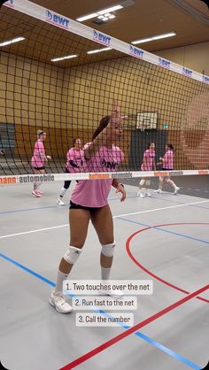 a woman in pink shirt and white socks playing volleyball on court with net behind her