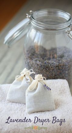 lavender drier bags are sitting on a towel next to a glass jar filled with lavenders