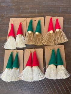 small christmas hats with tassels on top of brown paper and string attached to them