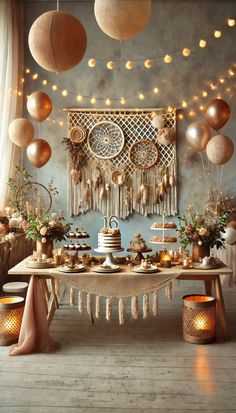 a table topped with lots of cake next to candles and balloons hanging from the ceiling