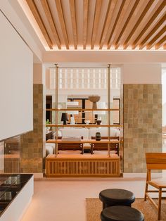 a living room filled with furniture and a fire place under a wooden ceiling mounted shelf