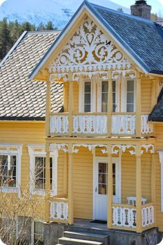 a yellow house with white balconies and windows