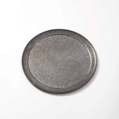 a round metal object sitting on top of a white surface