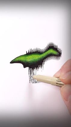 a hand holding a pencil drawing an image of a toothbrush with green and black streaks on it