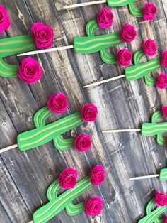 pink and green flowers are on sticks in the shape of cactuses with long stems