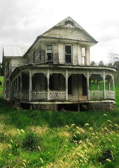 an old run down house sitting in the middle of a field