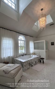 a bedroom with a large bed and chandelier hanging from the ceiling