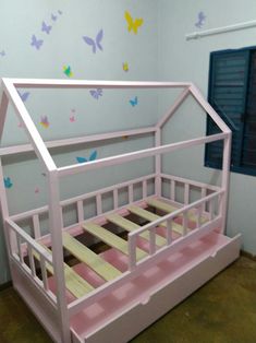 a pink bed frame with butterflies painted on the wall